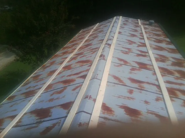 Rusted metal roof panels with new wood purlins before replacement — Storm Damage Roof Repair in Macomb by Roofing Brothers