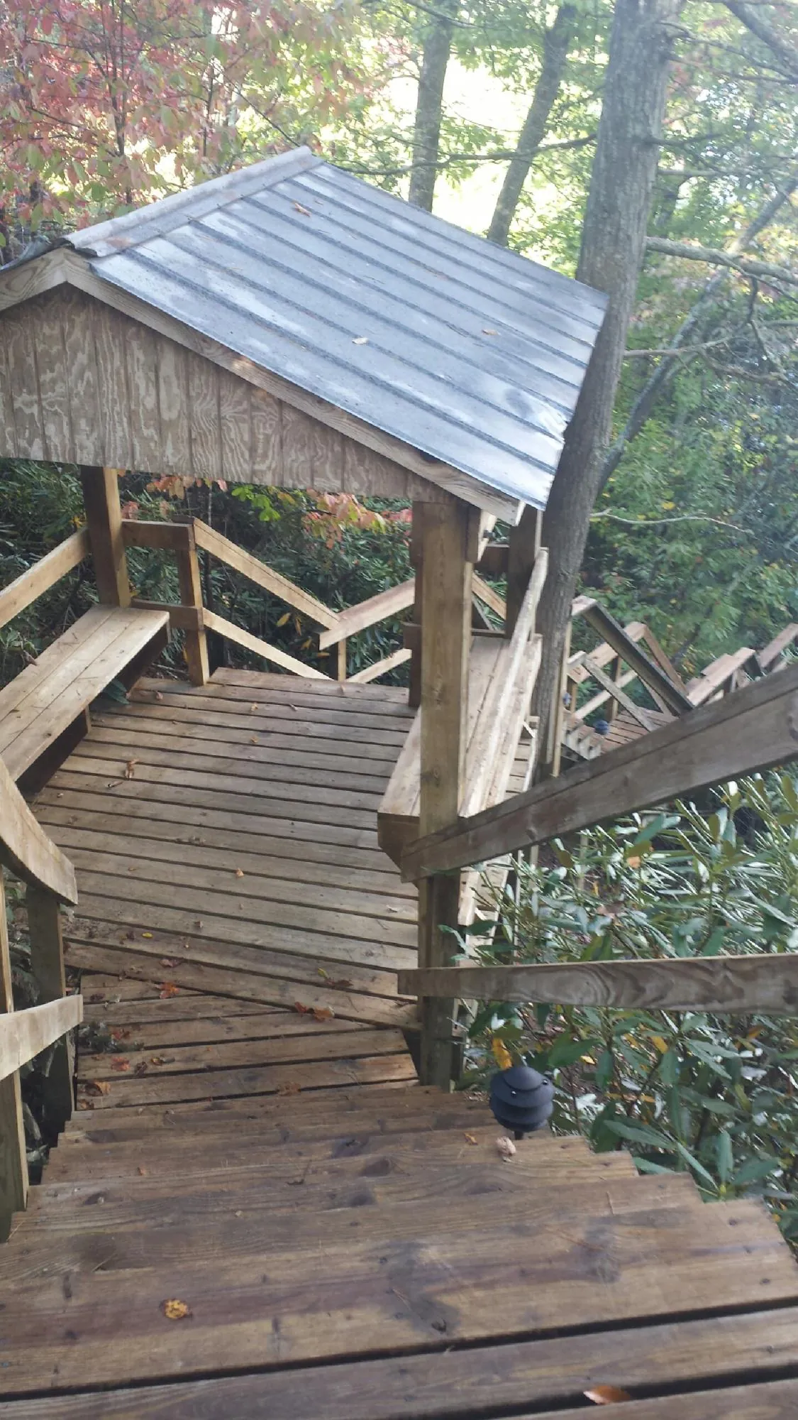Metal roofed shelter over wooden steps on a wooded walkway — Skylight Repair & Installation work by our crew in Macomb