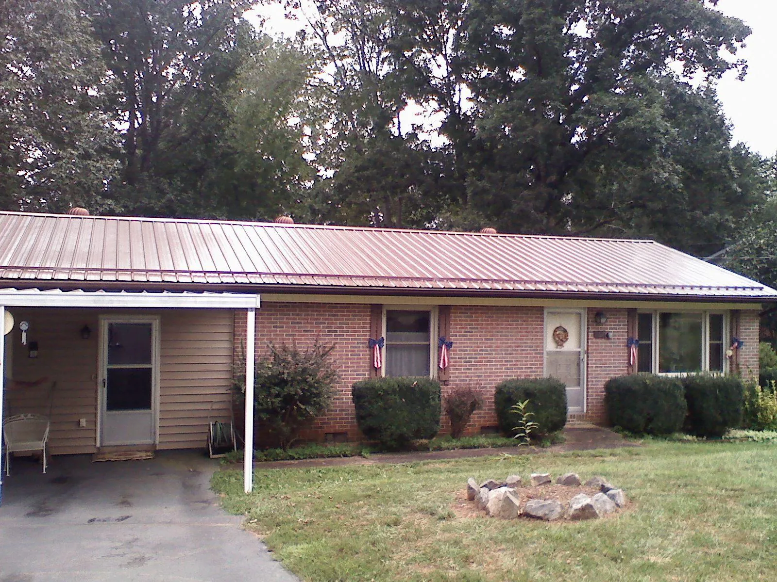 Bronze metal roof and carport on a brick ranch home — Roof Repair work by our crew in Macomb