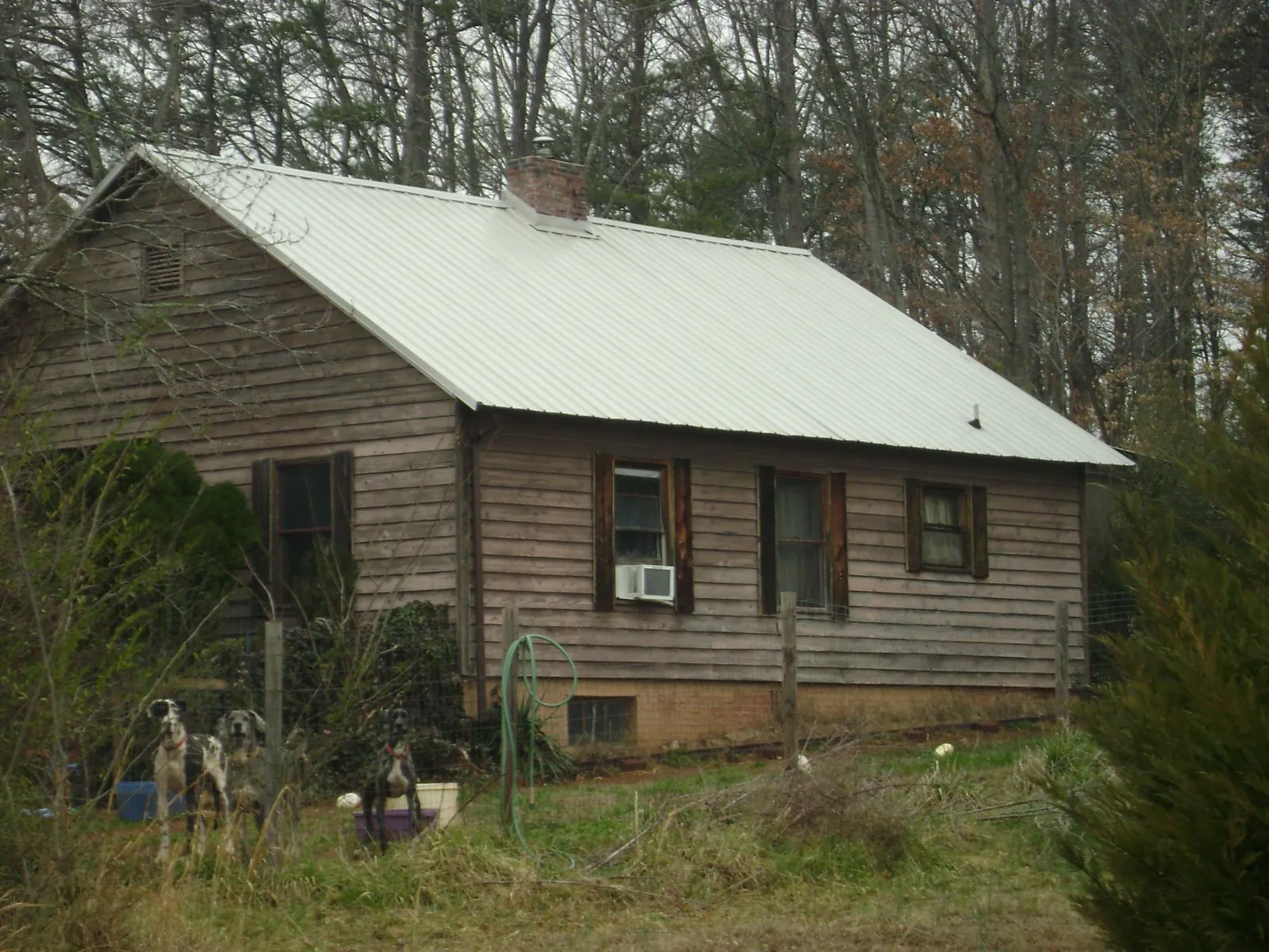 White metal roof on an old wood sided farmhouse, from a Metal Roof Installation job in Macomb